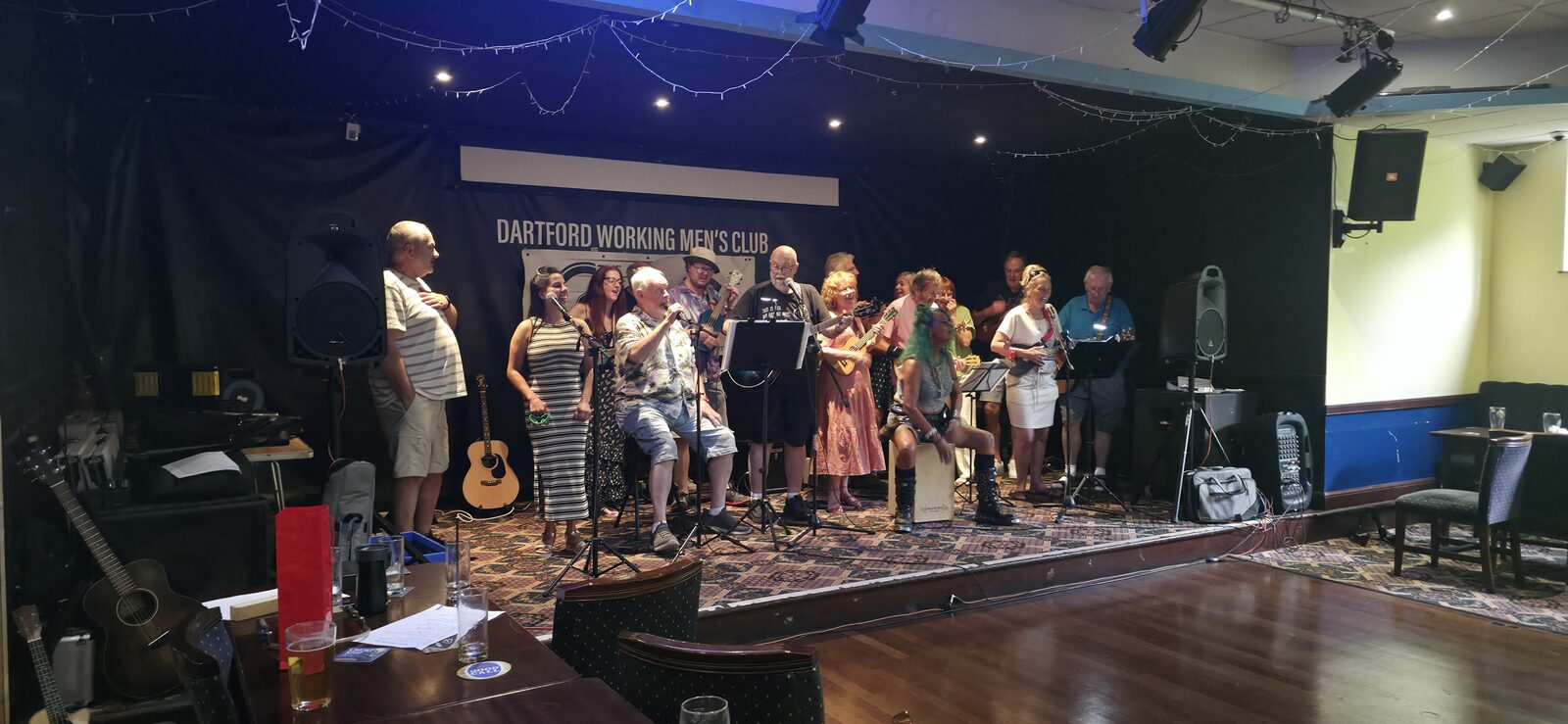 A community ukulele group performing together on stage at a local club