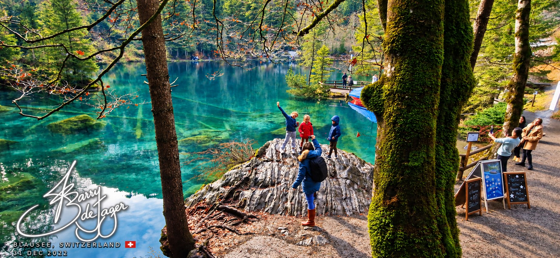 Clear blue alpine lake ringed by forest at Blausee