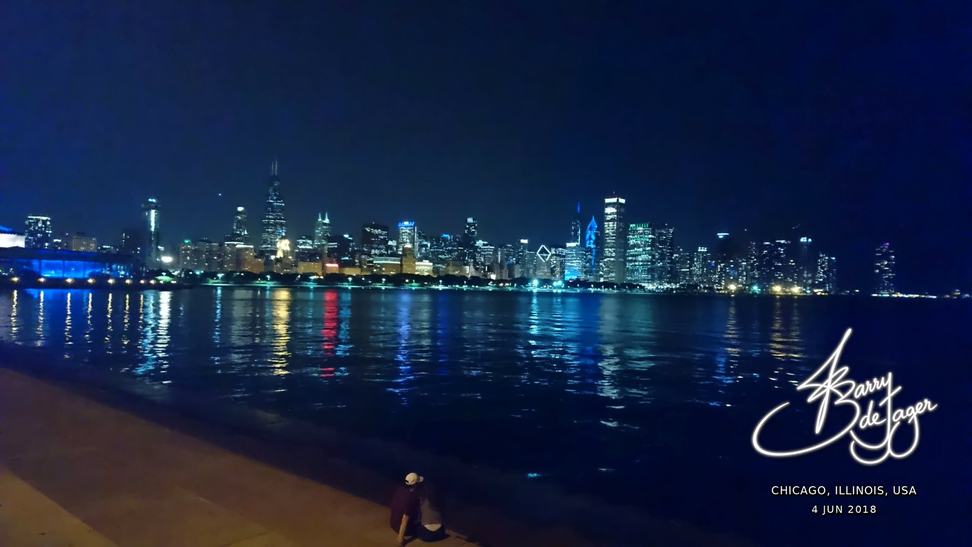Chicago skyline lit up at night and reflected across Lake Michigan