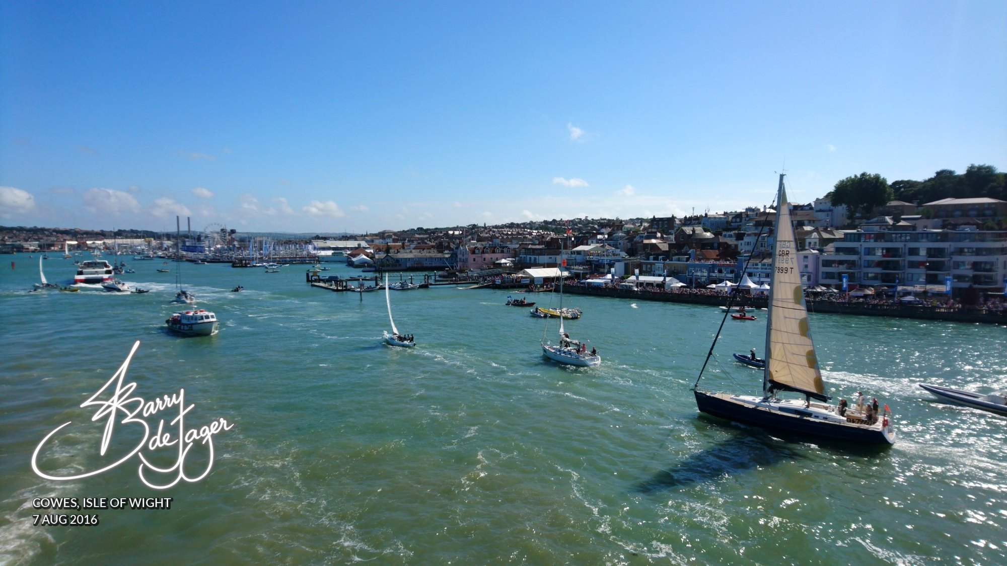 Yachts sailing across the bright harbour waters at Cowes on a sunny day